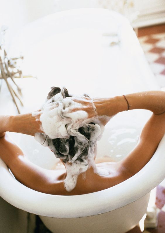 model washing hair in the bath