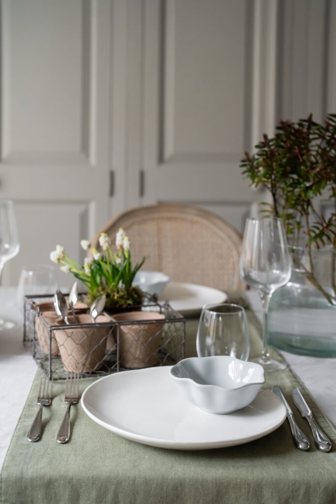 Kitchen table laid with Sophie Conran tableware, terracotta pots and Chef & Sommelier glasses